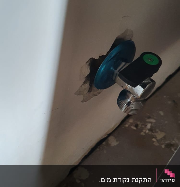 ברז מים מותקן בקיר עם חור מסביב